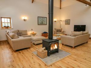 a living room with a wood stove in it at Hollowgill Barn in Sedbergh