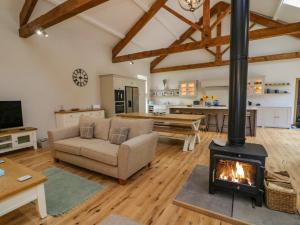 a living room with a couch and a fireplace at Hollowgill Barn in Sedbergh