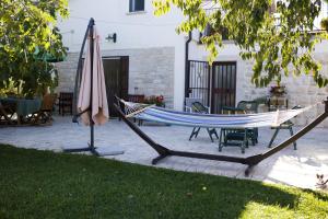 a hammock and an umbrella on a patio at La casetta di Eve Casa Vacanze in Guardialfiera