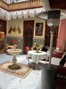 a living room with a table and a lamp at Riad Elijah Marrakech & Spa in Marrakech