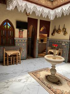 - un salon avec une fontaine au milieu d'une pièce dans l'établissement Riad Elijah Marrakech & SPA, à Marrakech