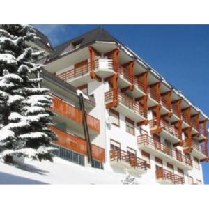 a building with balconies and a snow covered tree at Bilocale con vista a Sestriere in Sestriere