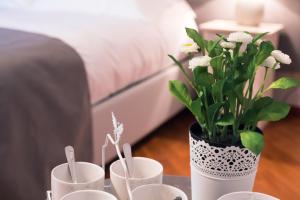 una mesa con tres tazas y un jarrón con flores en Casa Agnese, en Alba