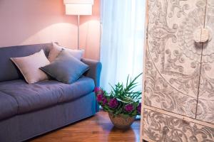 um sofá azul numa sala de estar com uma planta em Casa Agnese em Alba