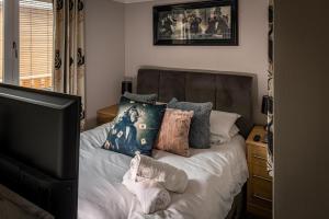 a bedroom with a bed with pillows and a television at Lakeland Lodge in Carnforth