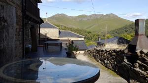 a patio with a glass table with a view of mountains at Casa Rural Las Nieves in San Ciprián