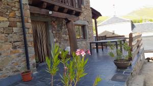 a stone building with potted plants on a patio at Casa Rural Las Nieves in San Ciprián