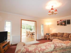 a living room with a couch and a television at Garden Lodge in Muir of Ord