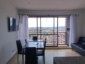 a living room with a table and a large window at Apartamento en zona norte bogota in Bogotá