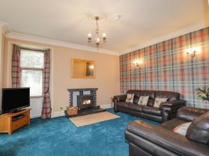 a living room with a couch and a fireplace at Balloan House in Muir of Ord