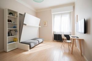 Sigieri Residence Milano في ميلانو: غرفة معيشة مع أريكة ومكتب