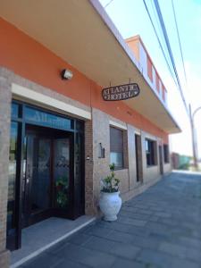 a building with a plant in a pot in front of it at Hotel Atlantic in Mar de Ajó