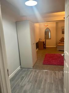an empty room with a door and a red rug at Y Teifi in Llandysul