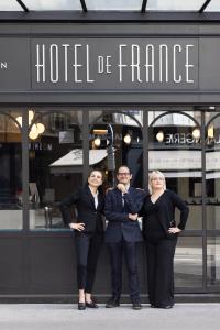 grupa trzech osób stojących przed budynkiem w obiekcie Hôtel de France Gare de Lyon Bastille w Paryżu