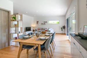 a dining room and living room with a table and chairs at Maison BOOA in Sévrier