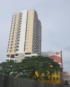 a tall building with a tree in front of it at Prestige KBCC at KB Town Centre in Kota Bharu