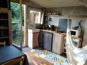 a small kitchen with a sink and a stove at La cabane en bois in Villemur-sur-Tarn