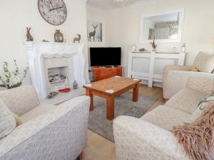 a living room with two couches and a fireplace at Llidiart Cerrig in Dyserth