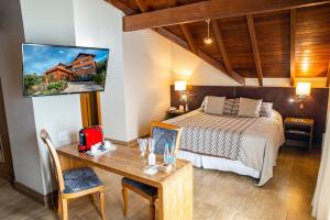 グラマドにあるHotel Refugio da Montanhaのベッドルーム1室(ベッド1台、壁掛けテレビ付きのデスク付)