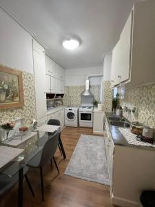 a kitchen with white cabinets and a table and chairs at Modern apartment in the heart of Athens. in Athens