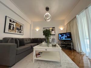 a living room with a couch and a tv at Modern apartment in the heart of Athens. in Athens