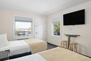 a hotel room with two beds and a flat screen tv at Beach Bum Inn in Ocean City