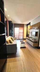 ein großes Wohnzimmer mit einem Sofa und einer Küche in der Unterkunft 103 - Rentaqui - Flat Apartamento Opera Confort no Jardins in São Paulo