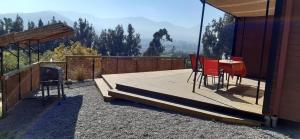 a wooden deck with a table and chairs on it at Cabaña Girasol - Cocina Parking Piscina Wifi in Algarrobito