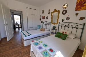 a bedroom with two beds and a mirror on the wall at Apartahotel Belchite in Belchite