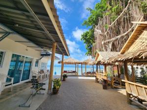 patio z ławkami i widokiem na ocean w obiekcie BeauBo Beach w mieście Baan Tai