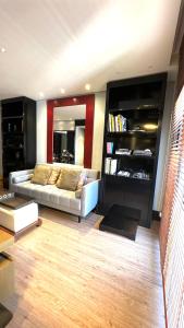sala de estar con sofá y estante para libros en 103 - Rentaqui - Flat Apartamento Opera Confort no Jardins, en São Paulo