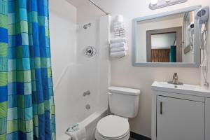 ein Badezimmer mit Toilette, Waschbecken und Spiegel in der Unterkunft Beach Bum Inn in Ocean City