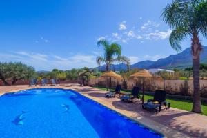 a swimming pool with chairs and a view of the mountains at Cubo's Finca Los Acebuches in Alhaurín el Grande
