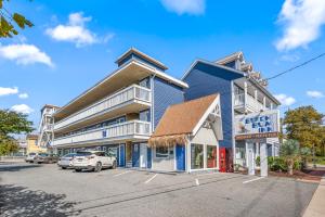 ein blaues Gebäude mit Autos auf einem Parkplatz in der Unterkunft Beach Bum Inn in Ocean City