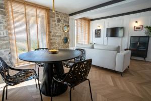 salon ze stołem, krzesłami i kanapą w obiekcie Restaurant & Villa Morgan w mieście Brtonigla