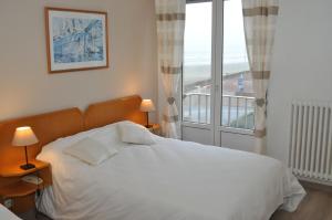 een slaapkamer met een wit bed en een raam bij Hotel La Terrasse in Fort-Mahon-Plage