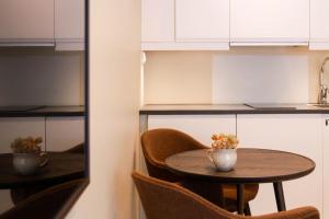una mesa y sillas en una cocina con armarios blancos en May's Apartments by May's en Reine