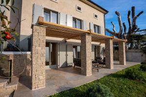 patio z drewnianą pergolą przed domem w obiekcie Restaurant & Villa Morgan w mieście Brtonigla