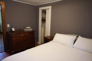 ein Schlafzimmer mit einem weißen Bett, einer Kommode und einem Fenster in der Unterkunft 3778 East Lake Road in Dunkirk
