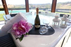 una mesa con una botella de vino y una flor en Appartamento 1 - La Poiana en Alberese