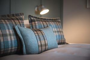 two plaid pillows sitting on top of a bed at Drumdry in Wick