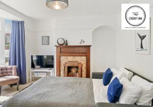 a bedroom with a bed and a fireplace at 3 Bedroom House with Parking & Garden By Cherry Inn Short Lets & Serviced Accommodation Cambridge in Cambridge