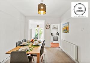 uma sala de jantar com mesa e cadeiras em 3 Bedroom House with Parking & Garden By Cherry Inn Short Lets & Serviced Accommodation Cambridge em Cambridge