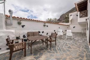 d'une terrasse avec des chaises, une table et un mur. dans l'établissement Casa Mercedes, Tamaimo, à Tamaimo