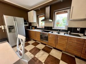 uma cozinha com armários de madeira e um piso em xadrez em Privát Adriana em Kremnica
