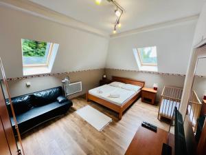 ein kleines Zimmer mit einem Bett und einem Sofa in der Unterkunft Privát Adriana in Kremnitz