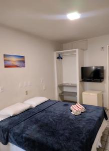 a bedroom with a large bed with two pillows on it at Santorini Praia Hotel in Natal