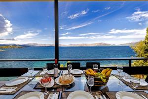 a table with a bowl of fruit and a view of the water at Es Balco, Villa over the mediterranean sea with private beach access in Cielo de Bonaire 