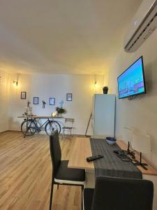 レッチェにあるIngrosso house Mini loft Lecceのテーブルと壁にテレビが置かれたリビングルーム