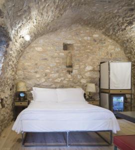 1 dormitorio con 1 cama en una pared de piedra en Tainaron Blue Retreat en Váthia